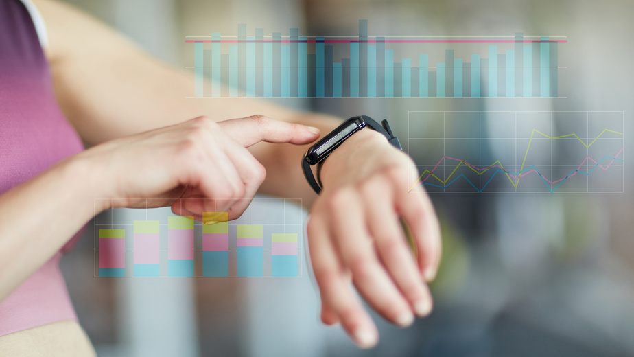 Frau kontrolliert Messwerte an Smart Watch bei Cardiofitness
